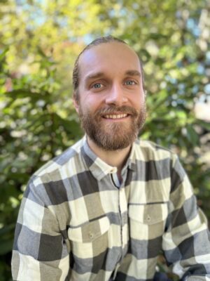 Mann med mørkt hår i hestehale. Foto.