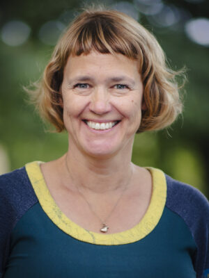 Kvinne med kort, mørkeblondt hår. Foto.