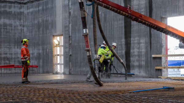 Byggeplass. Anleggsarbeidere som støper betong.