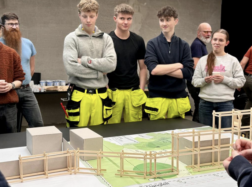 Skoleelever ser på tre-modell de har laget